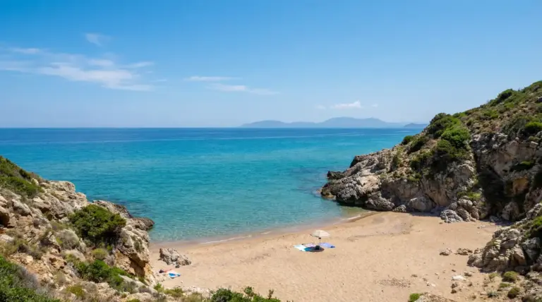 Spiaggia tranquilla con sabbia dorata e mare turchese circondata da scogli e natura