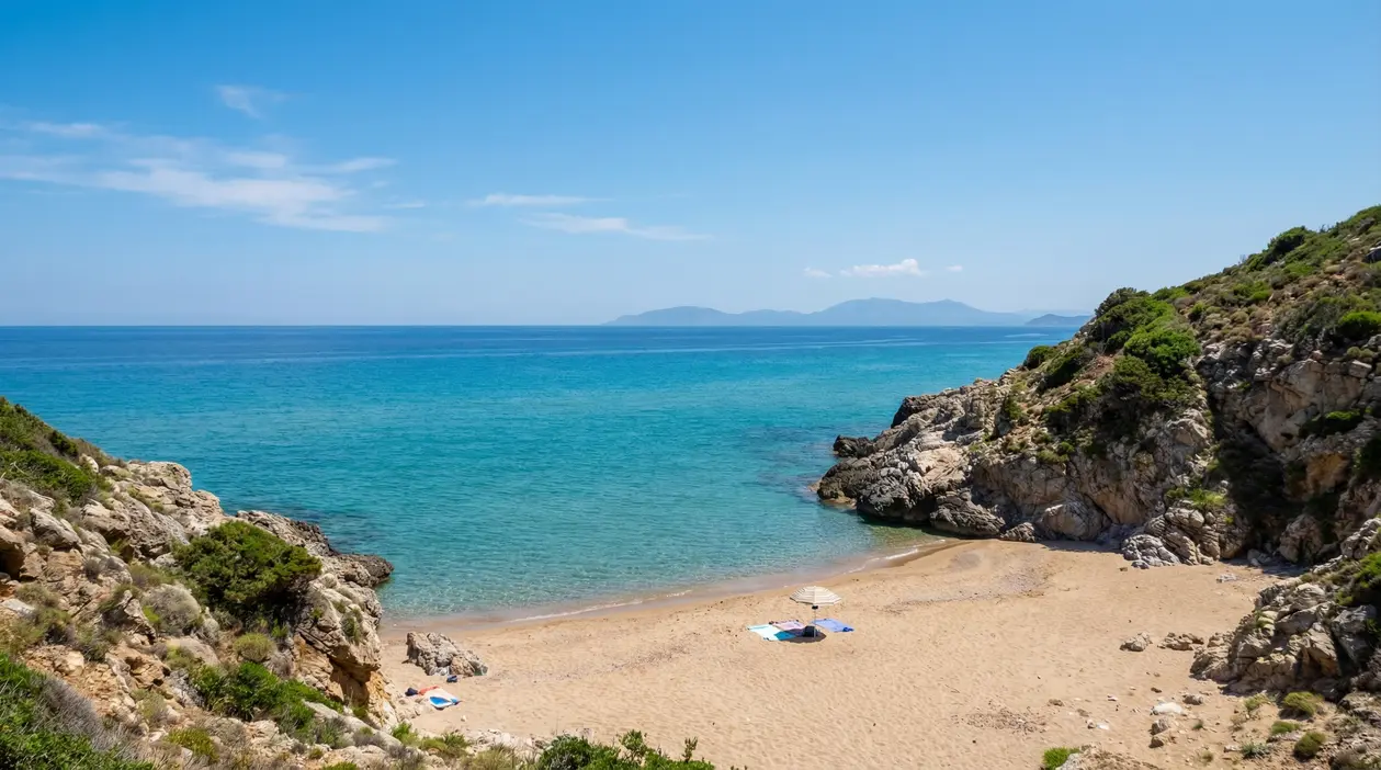 Spiaggia tranquilla con sabbia dorata e mare turchese circondata da scogli e natura